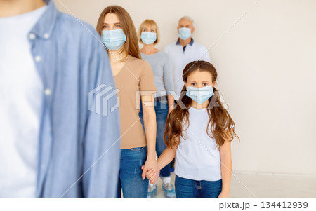 Parent and child in medical masks waiting in line for coronavirus vaccination at clinic. Covid-19 immunization, prevention of worldwide infectious disease outbreak concept Parent and child in medical masks waiting in line for coronavirus vaccination at clinic. Covid-19 immunization, prevention of worldwide infectious disease outbreak concept 134412939