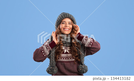 Portrait of pretty lady wearing fashionable knitted winter clothes on blue background 134413182