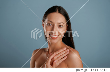 Clean skin. Young woman is in the studio against background 134413318