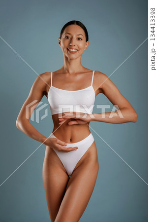 Diet conception. Young woman is in the studio against background Diet conception. Young woman is in the studio against background 134413398