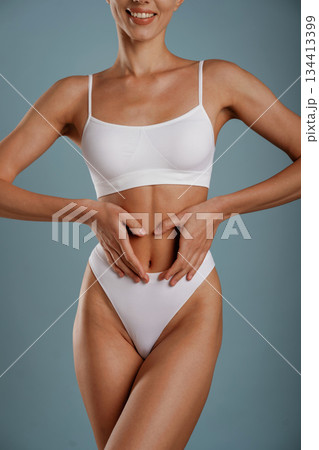Diet conception. Young woman is in the studio against background Diet conception. Young woman is in the studio against background 134413399