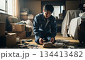 散らかった部屋で遺品整理をする男性作業員 134413482