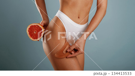 Standing, healthy eating concept, diet. Young woman is in the studio against background Standing, healthy eating concept, diet. Young woman is in the studio against background 134413533