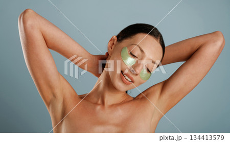 Against background. Eye patches. Young woman is in the studio Against background. Eye patches. Young woman is in the studio 134413579