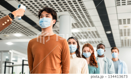 New Normal, Pandemic Outbreak Concept. Teacher Doing Temperature Screening Measuring Fever For Diverse Group Of People Standing In Queue, Using Infrared Contactless Themometer At The Entrance New Normal, Pandemic Outbreak Concept. Teacher Doing Temperature Screening Measuring Fever For Diverse Group Of People Standing In Queue, Using Infrared Contactless Themometer At The Entrance 134413673