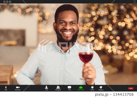 Stay Safe At Home, Social Distancing, Isolation. Cheerful happy black man skyping on computer, having romantic online date with his partner, holding glass of red wine and toasting, monitor view Stay Safe At Home, Social Distancing, Isolation. Cheerful happy black man skyping on computer, having romantic online date with his partner, holding glass of red wine and toasting, monitor view 134413708