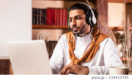 Teacher Man Having Virtual Lesson Via Video Call On Laptop Sitting Wearing Headphones At Computer Indoors. Remote Education, Online Tutoring And E-Teaching Concept. Selective Focus Teacher Man Having Virtual Lesson Via Video Call On Laptop Sitting Wearing Headphones At Computer Indoors. Remote Education, Online Tutoring And E-Teaching Concept. Selective Focus 134413745