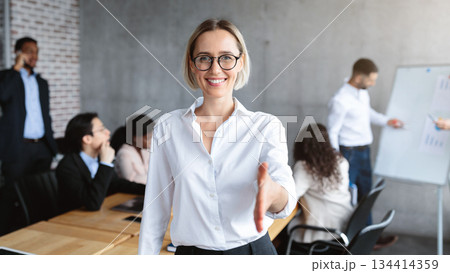Female HR Manager Stretching Hand For Handshake Greeting To Camera Standing In Modern Office. Career Offer, Recruitment And Employment, Human Resources Concept. Selective Focus 134414359