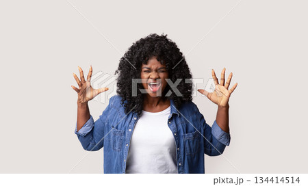 Furious young black woman raising hands up and screaming, showing her negative emotions over grey studio background. Emotional african american lady expressing anger or annoying Furious young black woman raising hands up and screaming, showing her negative emotions over grey studio background. Emotional african american lady expressing anger or annoying 134414514