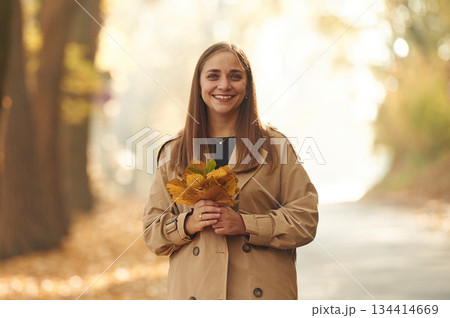 Happy woman is in the autumn forest Happy woman is in the autumn forest 134414669