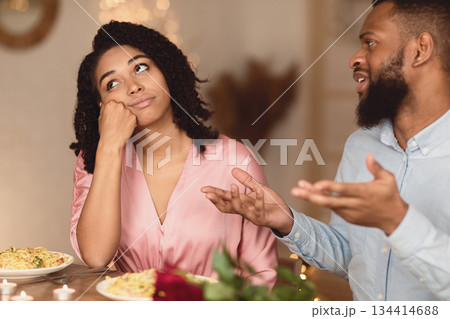 Bored unhappy black girlfriend listening to African American boyfriend in cafe, bad first impression and date concept, young couple sitting at table, talking, having problem in relationships Bored unhappy black girlfriend listening to African American boyfriend in cafe, bad first impression and date concept, young couple sitting at table, talking, having problem in relationships 134414688
