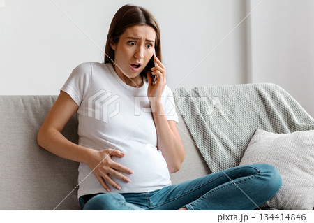 Labor Time. Worry Pregnant Woman Calling To Doctor, Feeling Cramps In Abdomen While Sitting On Couch At Home, Expectant Lady Suffering From Acute Belly Ache And Contractions, Copy Space Labor Time. Worry Pregnant Woman Calling To Doctor, Feeling Cramps In Abdomen While Sitting On Couch At Home, Expectant Lady Suffering From Acute Belly Ache And Contractions, Copy Space 134414846