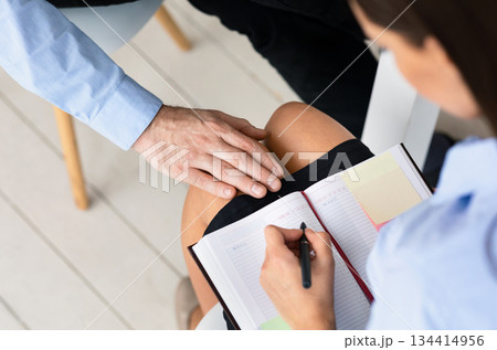 Sexual Harassment At Work. Businessman Harassing Woman Colleague Touching Her Knee Working Sitting In Office. Cropped, High-Angle 134414956