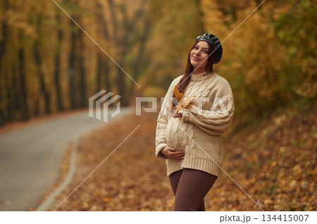 Pregnant woman is standing in the autumn forest Pregnant woman is standing in the autumn forest 134415007
