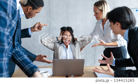 Conflict At Work. Unhappy Businesswoman Screaming Covering Ears While Aggressive Coworkers Shouting At Her Sitting In Modern Office. Corporate Communication Problem, Adult Bullying And Blaming 134415265