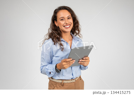 Smiling caucasian young businesswoman use tablet, app for social networks, presentation business, isolated on gray studio background. Work and chat on gadget, study online with technology Smiling caucasian young businesswoman use tablet, app for social networks, presentation business, isolated on gray studio background. Work and chat on gadget, study online with technology 134415275