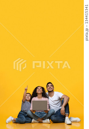 Great Offer. Joyful Arab Family Of Three With Laptop Pointing Up At Copy Space Above Their Heads, Interested Middle Eastern Parents And Little Daughter Looking At Free Place For Advertisement Great Offer. Joyful Arab Family Of Three With Laptop Pointing Up At Copy Space Above Their Heads, Interested Middle Eastern Parents And Little Daughter Looking At Free Place For Advertisement 134415341