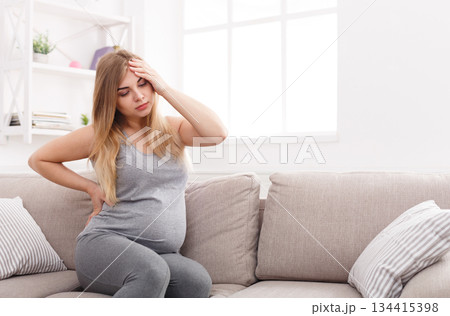 Young pregnant woman with headache and backache copy space. Pregnancy symptoms, healthcare concept 134415398