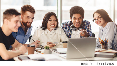 Group of multiracial students studying in library using laptop, preparing for exams together Group of multiracial students studying in library using laptop, preparing for exams together 134415400