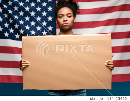 Mass ptotests in USA. Black girl standing with blank cardboard over american flag 134415436