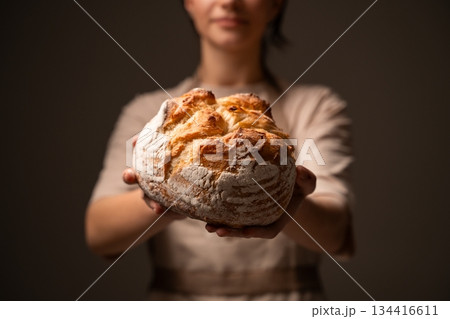 Artisan baker presenting rustic handmade bread loaf, showcasing traditional craftsmanship and natural quality Artisan baker presenting rustic handmade bread loaf, showcasing traditional craftsmanship and natural quality 134416611