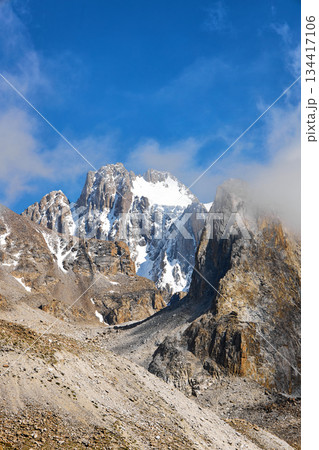 High mountain peak with snow and rock under a blue sky, representing nature adventure and majestic landscape. High mountain peak with snow and rock under a blue sky, representing nature adventure and majestic landscape. 134417106