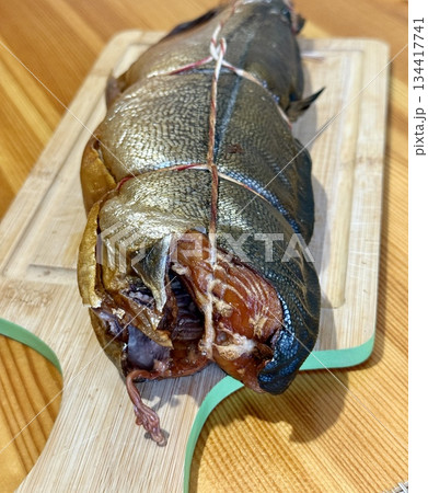 Cold hot smoked mackerel, beautifully laid out on a wooden chopping board, is ready for cooking and serving and is perfect for culinary themes. 134417741
