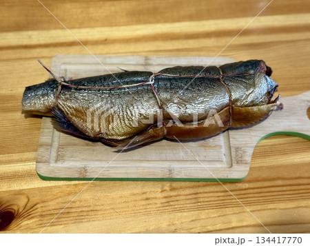 Cold hot smoked mackerel, beautifully laid out on a wooden chopping board, is ready for cooking and serving and is perfect for culinary themes. 134417770