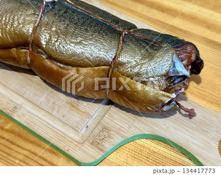 Cold hot smoked mackerel, beautifully laid out on a wooden chopping board, is ready for cooking and serving and is perfect for culinary themes. 134417773