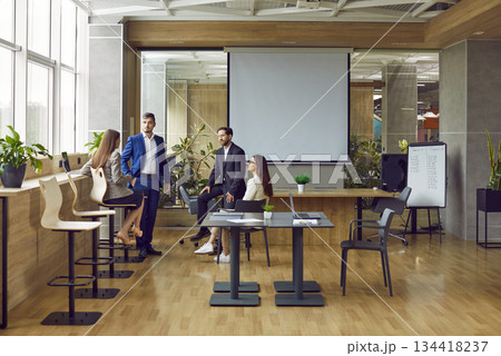 Team of four young people meeting in a modern office interior in a business center Team of four young people meeting in a modern office interior in a business center 134418237
