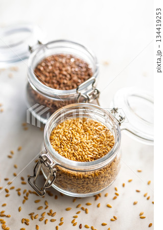 Golden linseed or flaxseed. Healthy flax seed in jar on kitchen table. 134419253