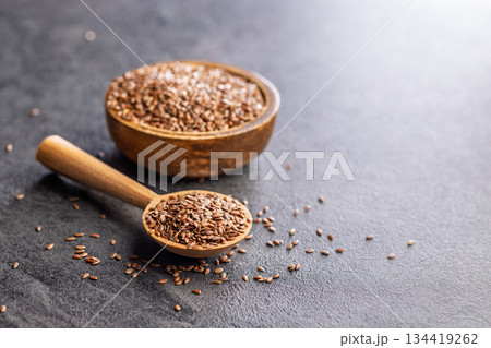Linseed or flaxseed. Healthy flax seed on wooden spoon on black table. Linseed or flaxseed. Healthy flax seed on wooden spoon on black table. 134419262