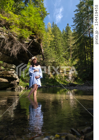 Woman Enjoying a Tranquil Forest Stream 134419458