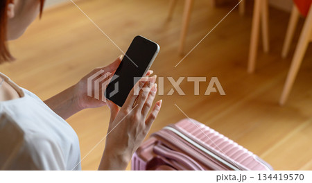 ホテル客室でスマホ操作する旅行女性 134419570