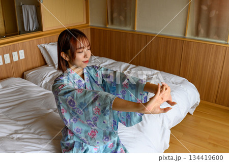 浴衣姿の女性がベッドでストレッチ 134419600