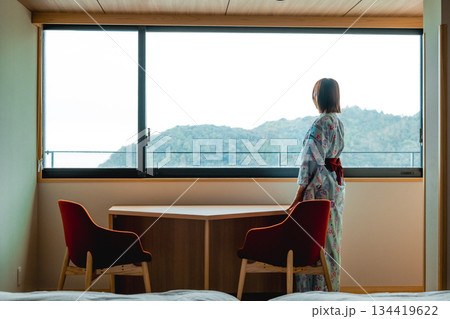 浴衣姿の女性と窓外の山景色 浴衣姿の女性と窓外の山景色 134419622