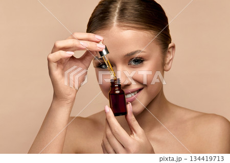 Skincare and serum with portrait of  luxury woman in studio for cosmetics, peptides and facial. Self care, glow and beauty extract with person on white background for clean, product and spa 134419713