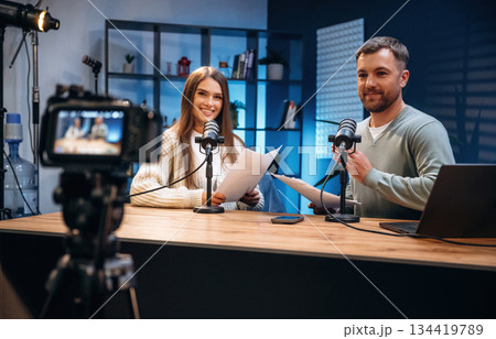 Tow people, together. Radio hosts recording podcast 134419789