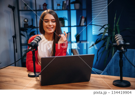 Woman is hosting radio podcast with microphone and laptop Woman is hosting radio podcast with microphone and laptop 134419904