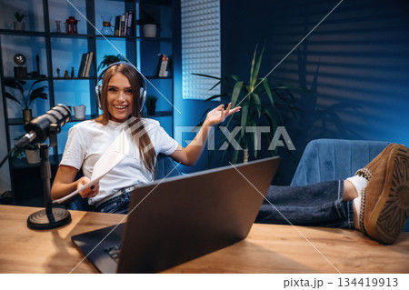 Woman is hosting radio podcast with microphone and laptop Woman is hosting radio podcast with microphone and laptop 134419913