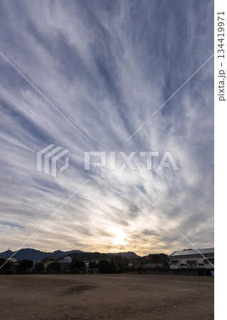 広いグランドと秋の夕空の素材写真　すじ雲と夕日 134419971