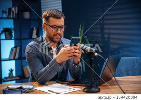 Trading expert is analyzing data. Man with microphone in the studio, conception of podcast Trading expert is analyzing data. Man with microphone in the studio, conception of podcast 134420004