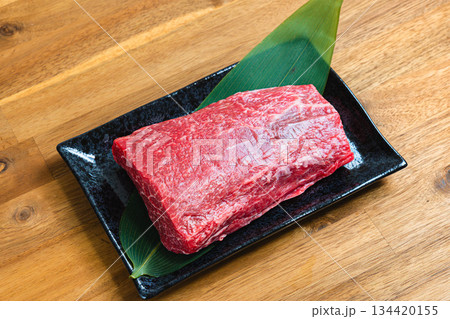 牛肩肉のブロック 生肉の食材写真 黒い器と木目テーブル 牛肩肉のブロック 生肉の食材写真 黒い器と木目テーブル 134420155
