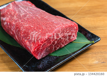 牛肩肉のブロック 生肉の食材写真 黒い器と木目テーブル 134420160