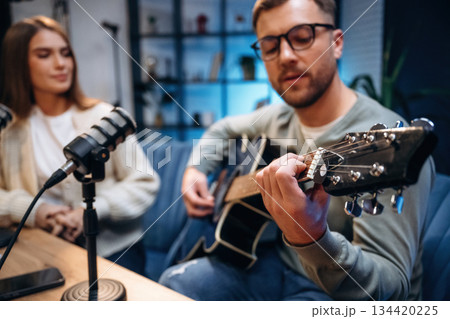 Singing with passion. Male musician on the radio podcast with female host 134420225