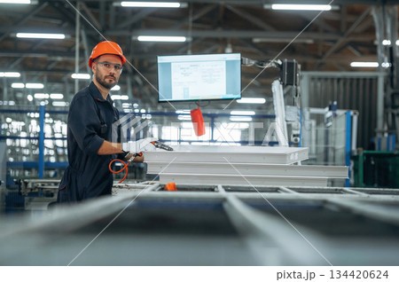 Indoors in the factory, standing. Man is working Indoors in the factory, standing. Man is working 134420624