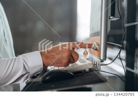 Typing on the keyboard. Close up view of man that is working in the modern factory 134420705