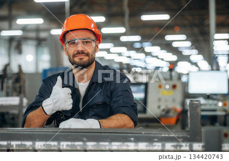 Showing thumb up. Man is working in the modern factory Showing thumb up. Man is working in the modern factory 134420743