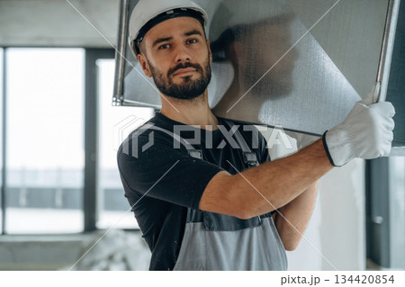 Moving stuff. A man is renovating an unfinished room 134420854