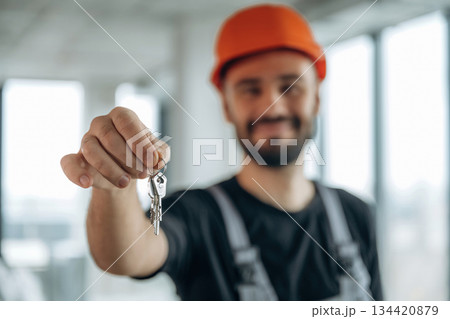 Buy it. Happy construction worker is holding keys for new home 134420879